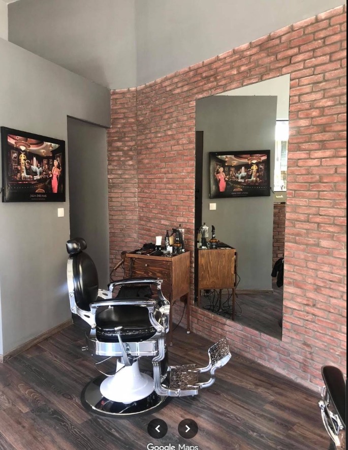 Πολυθρόνα barber μπροστά σε καθρέφτη και τούβλα
